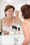 Closeup of senior woman putting makeup on